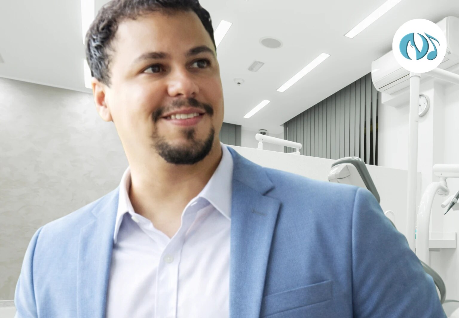 Dr. Nicholas Trajano em seu consultório, de blazer azul
