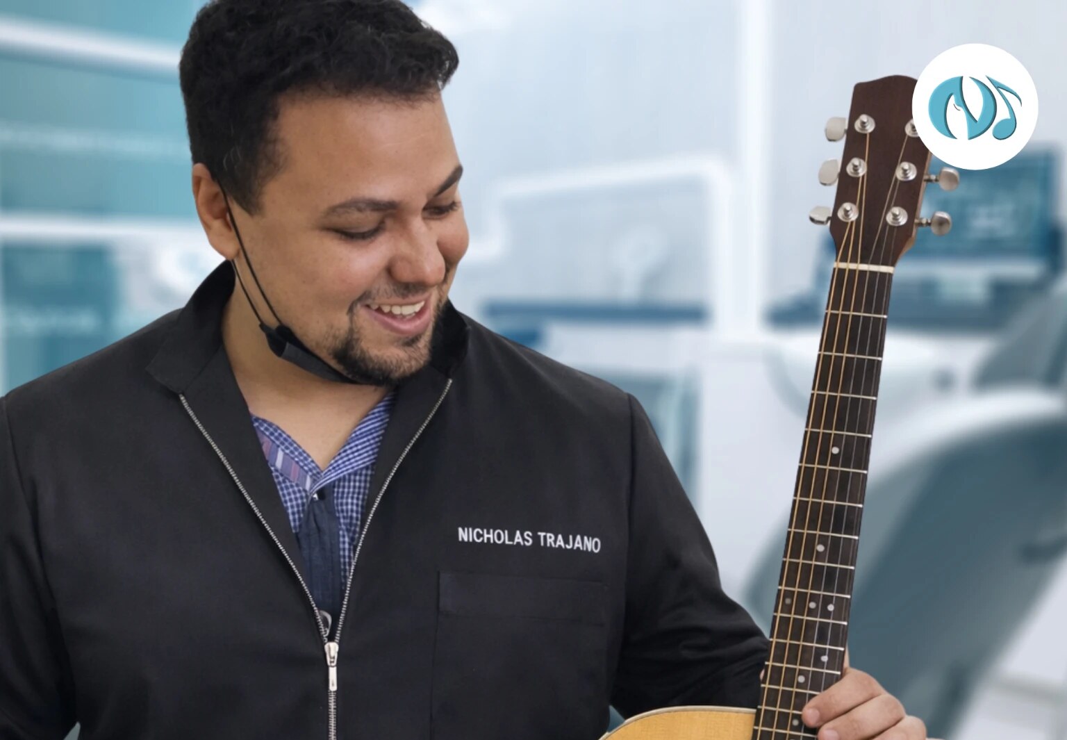 Dr. Nicholas Trajano sorrindo com seu violão, unindo odontologia e musicoterapia